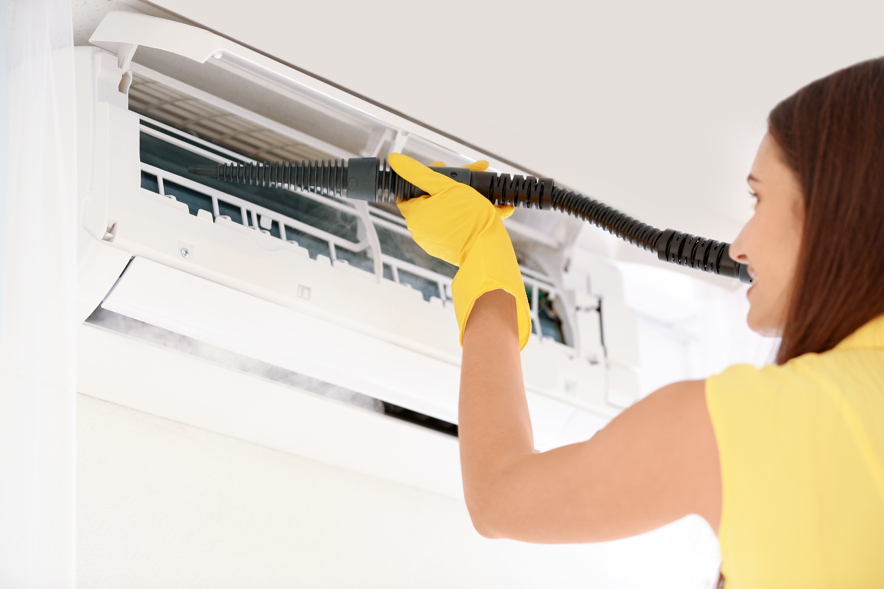 Woman Cleaning Air Conditioner